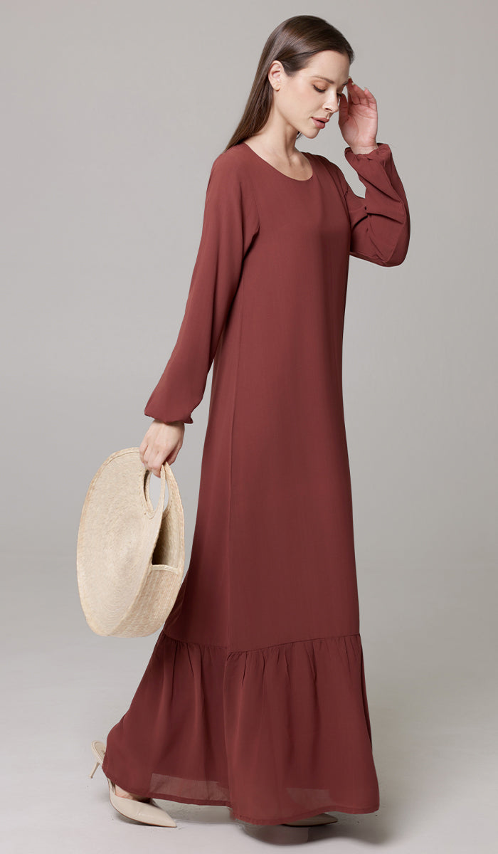 Woman wearing Batool dress in Brick. 