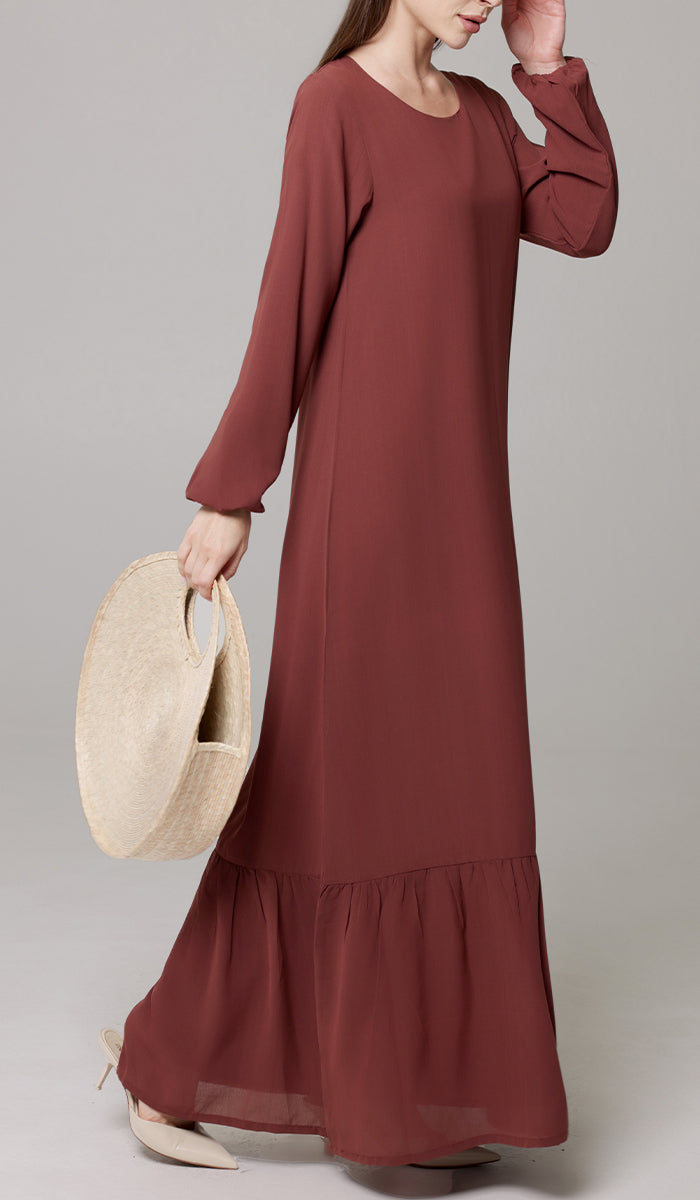 Woman walking wearing Batool dress in Brick. 