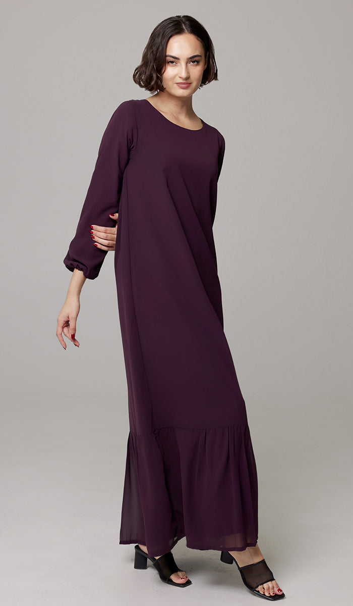 Woman wearing Batool dress in Mulberry with black heels. 