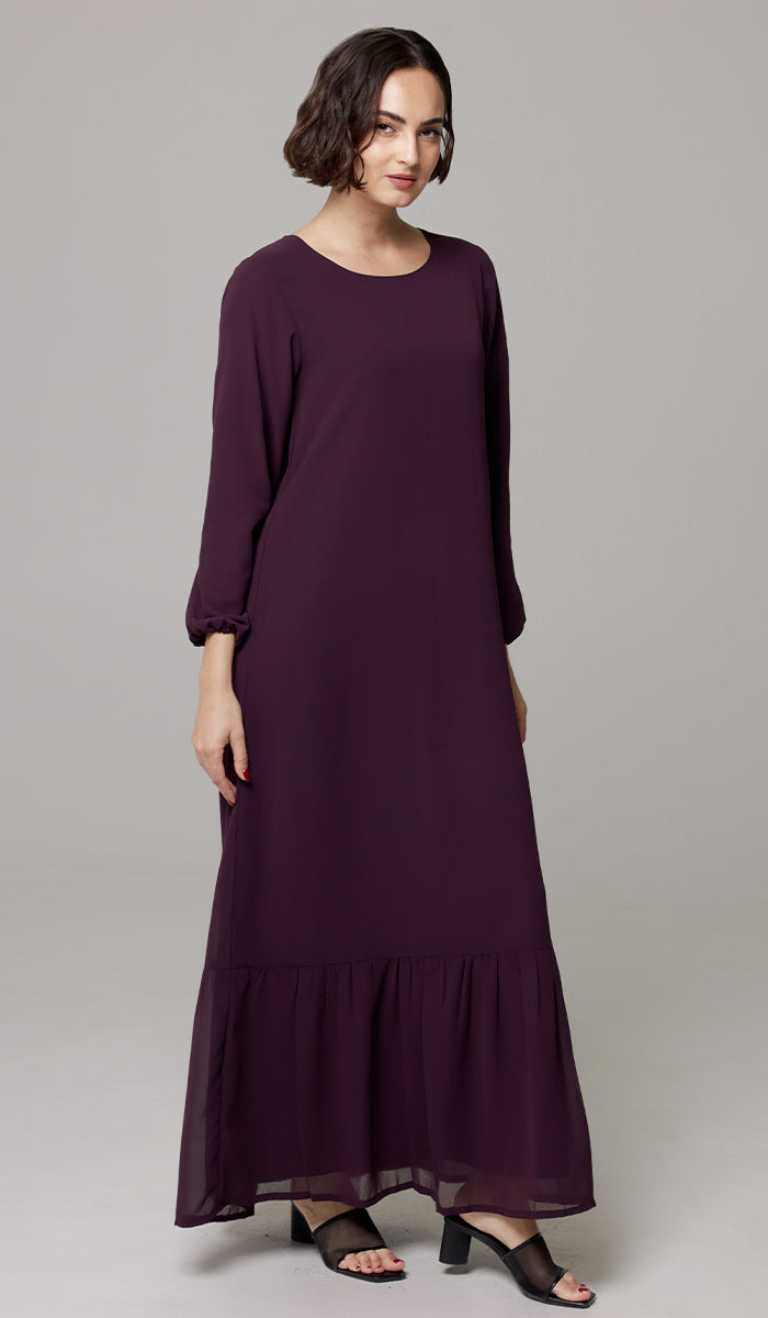 Woman wearing modest Batool dress in Mulberry. 