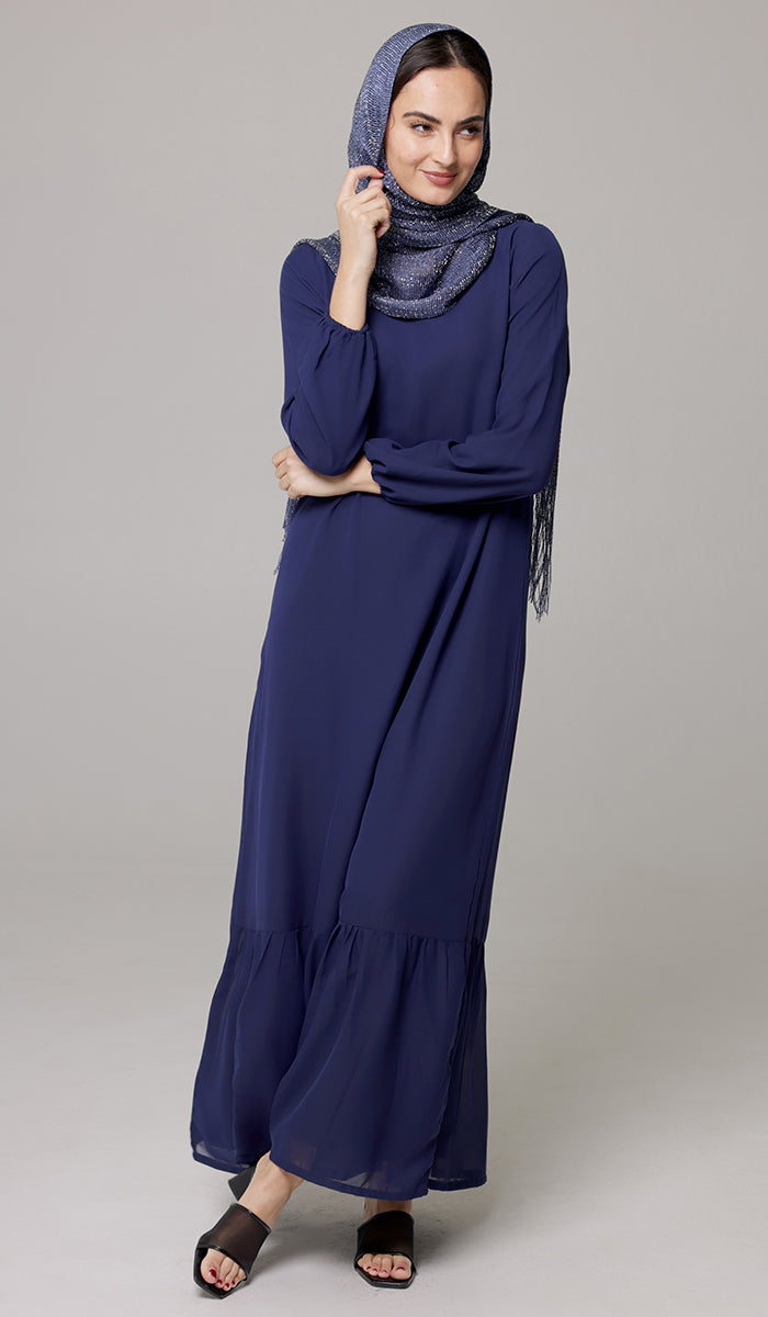 Woman looking to the side wearing Batool dress in Navy Blue with hijab. 