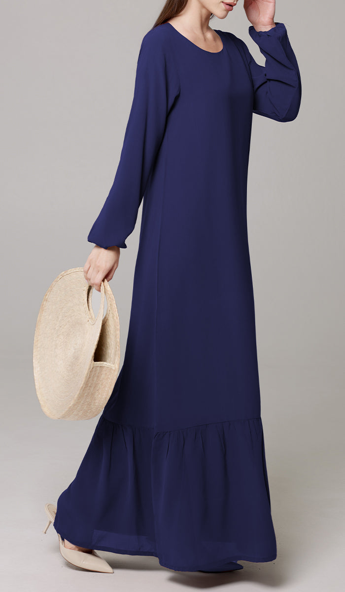 Woman wearing Batool dress in Navy Blue with purse and heels. 