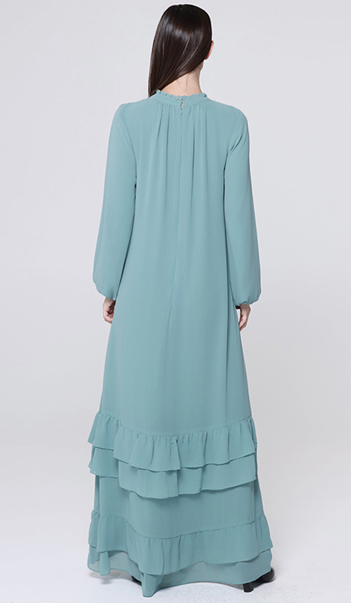 Teal long-sleeve dress with ruffled layers on a white background