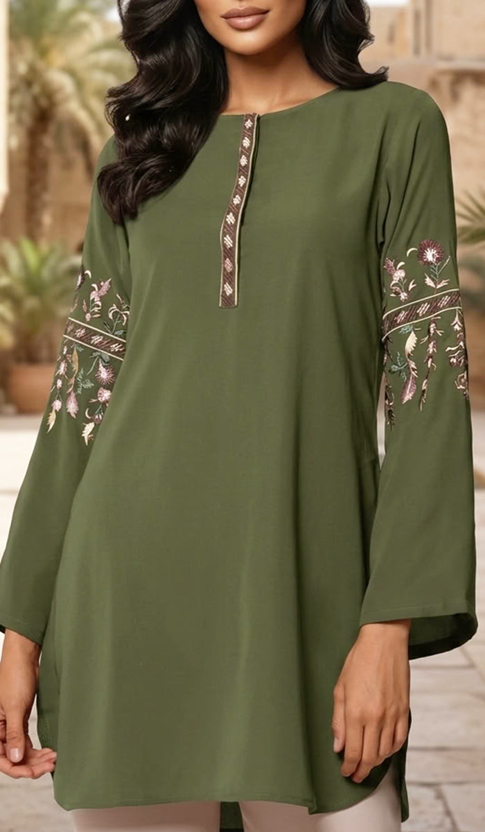 An olive green long-sleeve tunic top with floral embroidery on the sleeves and a decorative vertical panel at the neckline, shown on a model in an outdoor setting.