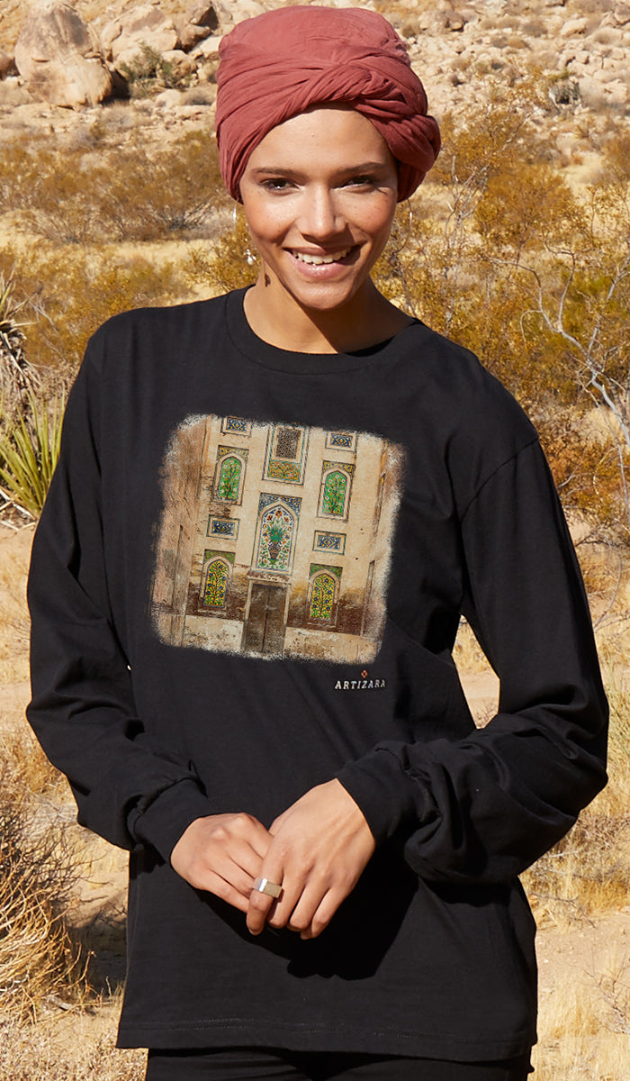 Woman wearing a black long-sleeve shirt with a graphic design in a desert setting