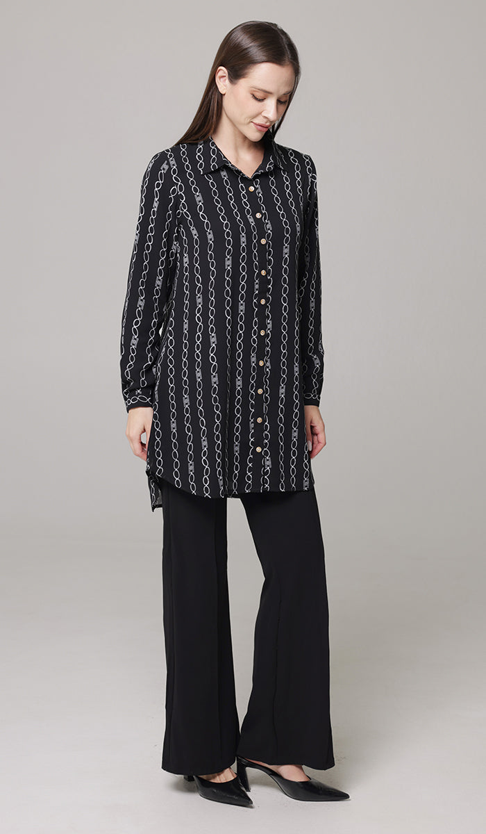 Woman wearing Marwa tunic in Black/White with black pants and heels. 