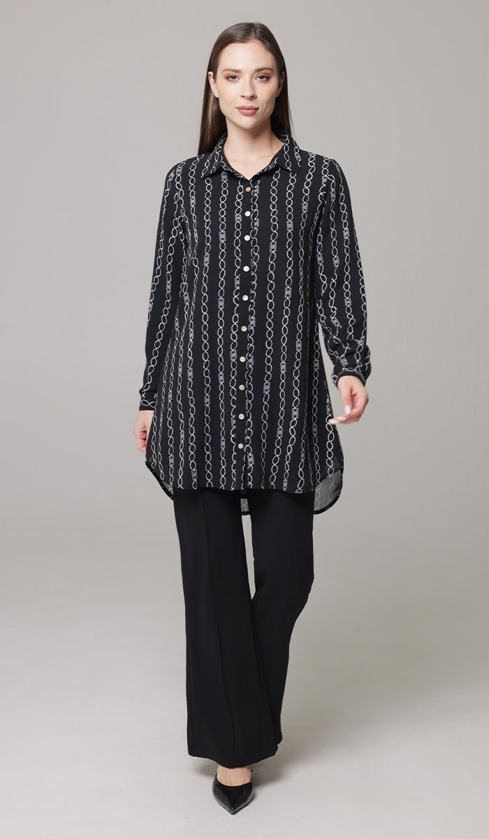 Woman walking wearing Marwa tunic in Black/White with black pants and heels. 
