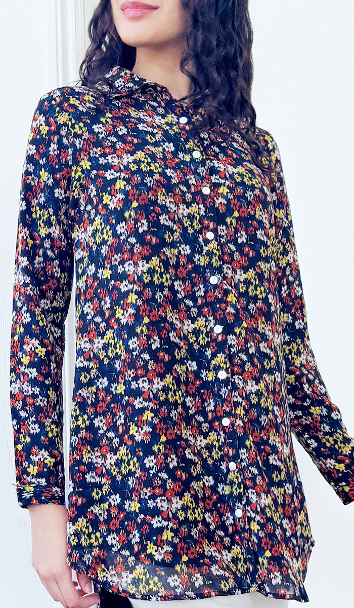 Woman wearing a long-sleeve floral dress with a white background