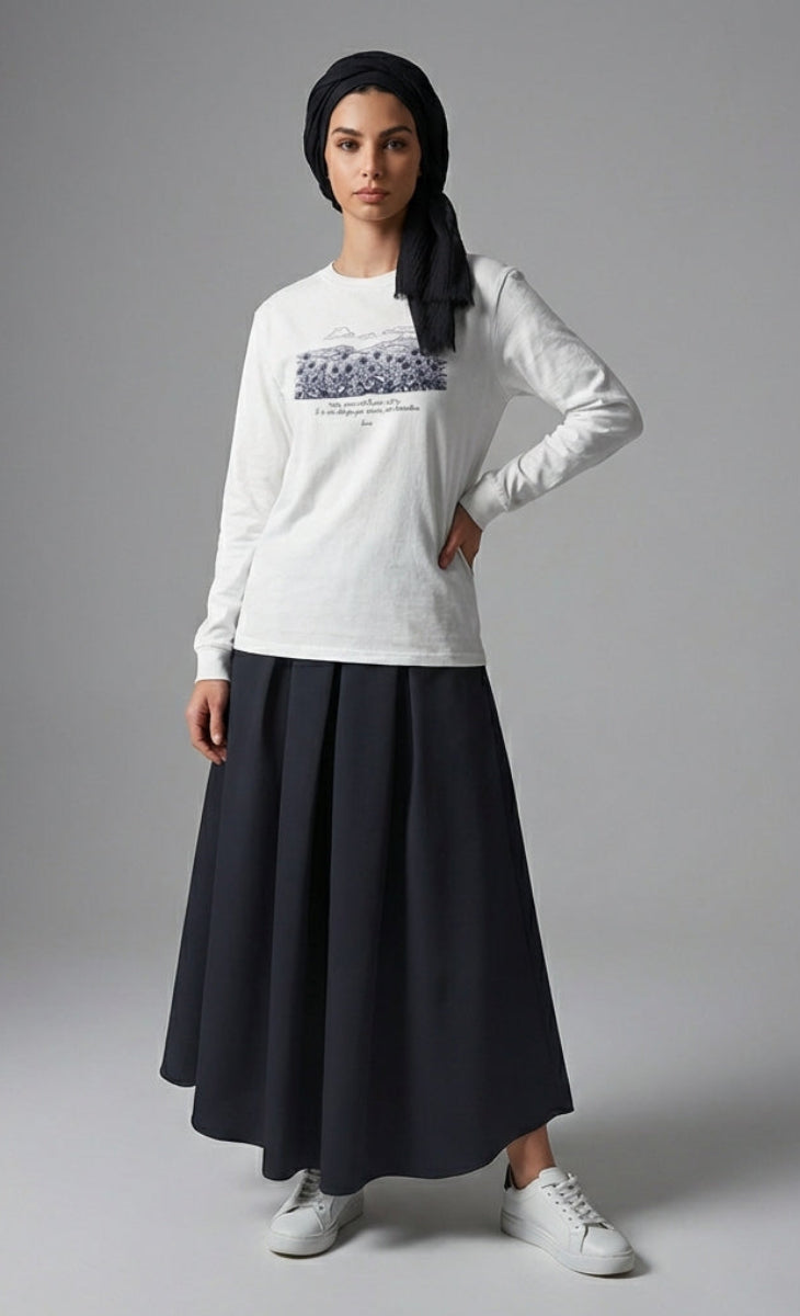 Woman wearing a white long-sleeve shirt with a black skirt on a gray background