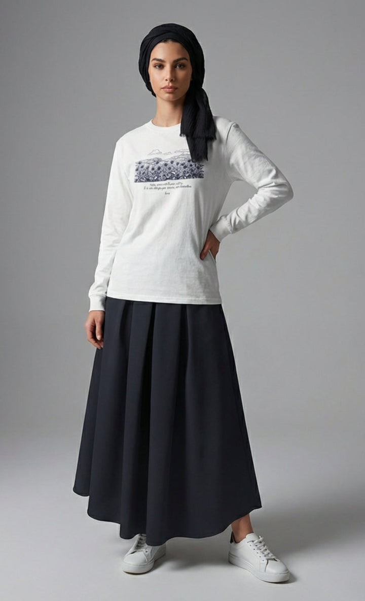 Woman wearing a white long-sleeve shirt with a black skirt on a gray background