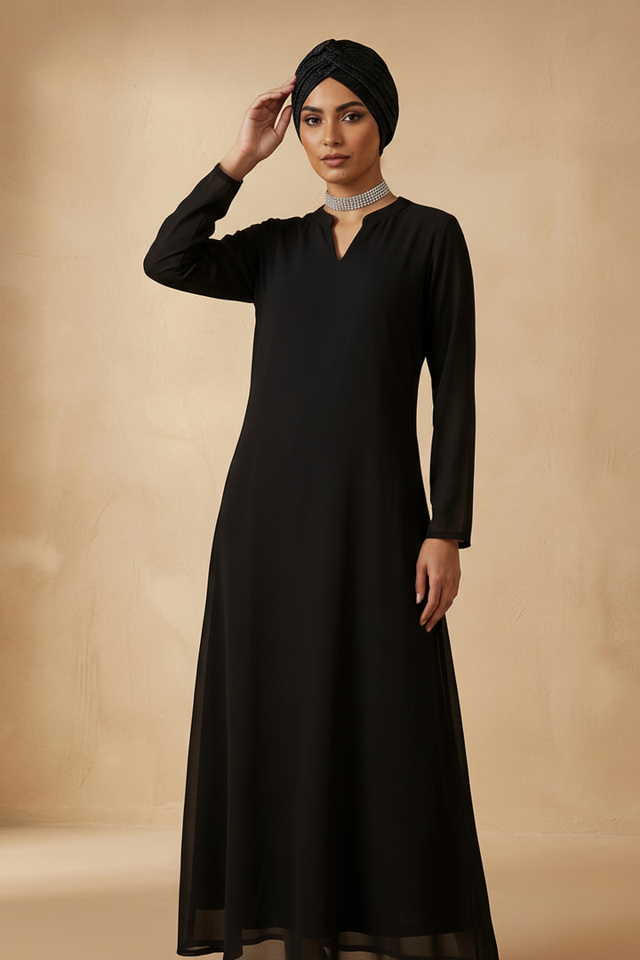 Woman wearing a black long-sleeve dress against a beige background