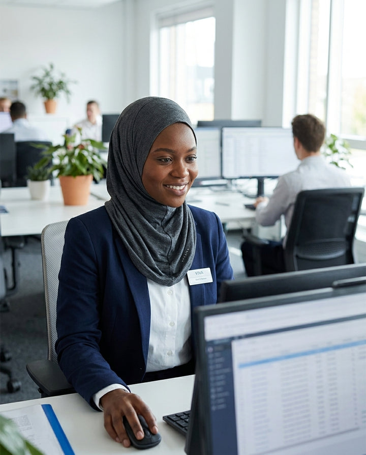 Woman wearing a hijab and working at a computer in an office setting
