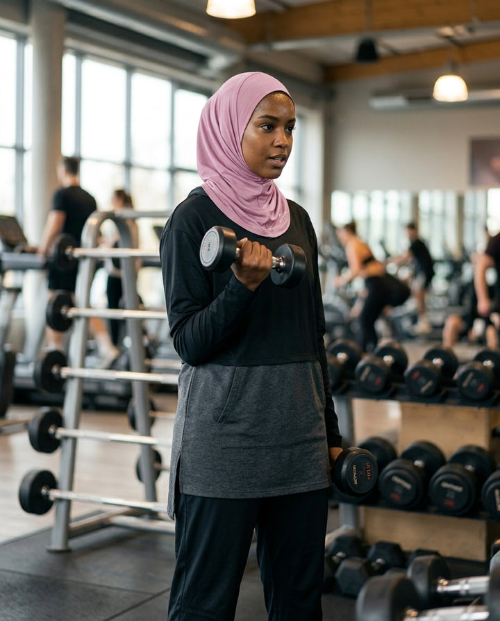 Woman exercising with dumbbells in a gym setting