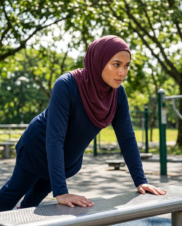 Woman in a hijab exercising on a bench in a park
