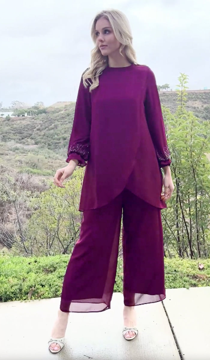 Woman outside wearing Seema tunic in Orchid with pants and heels. 