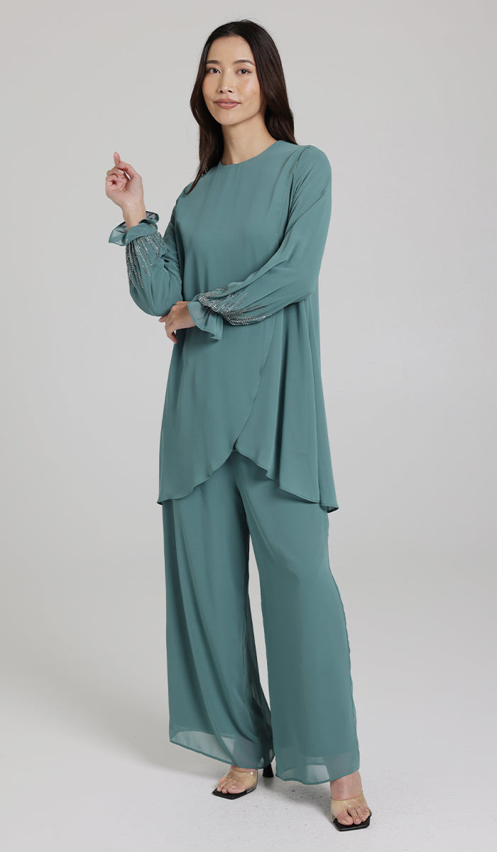 Woman smiling wearing Seema tunic in Seagreen with pants and heels. 