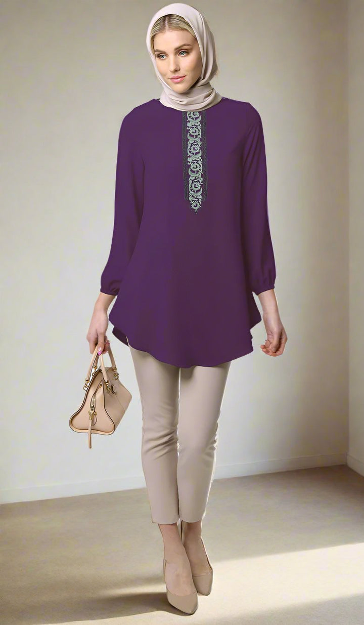 Woman wearing Suroor tunic in Dark Purple with khaki pants, heels, and a purse. 