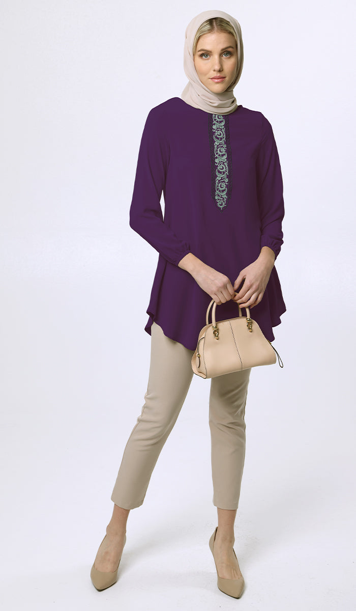 Woman wearing hijab with Suroor tunic in Dark Purple with khaki pants, heels and purse. 