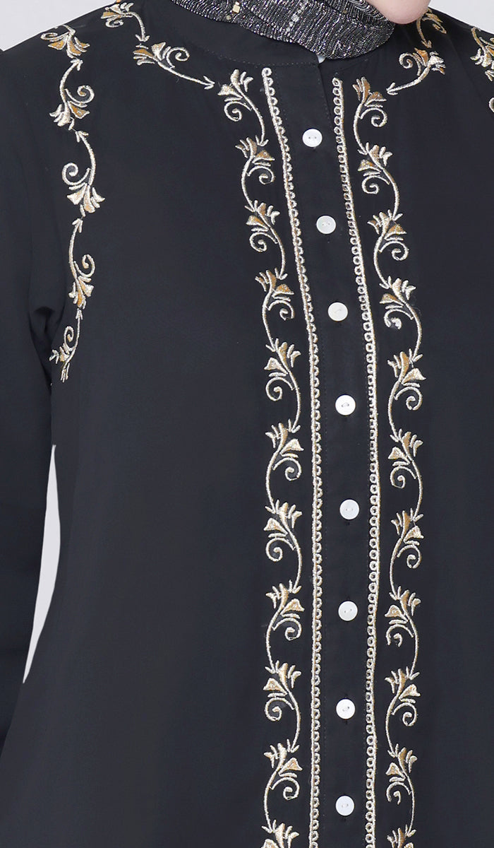 Black garment with gold embroidery and white buttons on a white background