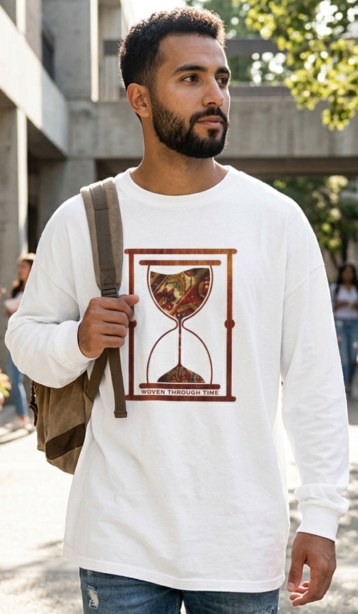 A man wearing a white long-sleeve t-shirt with a brown graphic of an hourglass and the text 'TIME IS WORTH THE PRICE' on the front, carrying a brown shoulder bag in an outdoor setting.