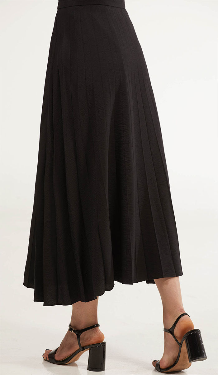 Back view of woman wearing Amani skirt in Black with heels. 