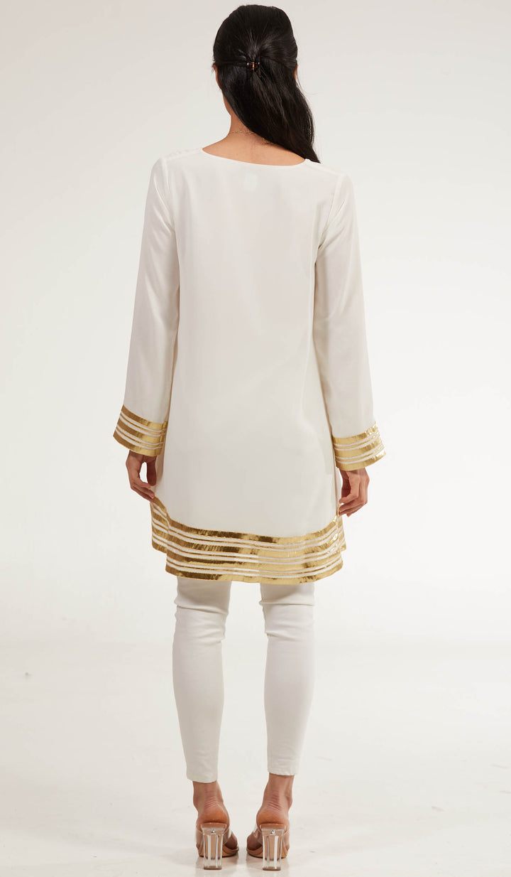 Back view of woman wearing Sultana tunic in Off White with white pants and heels. 