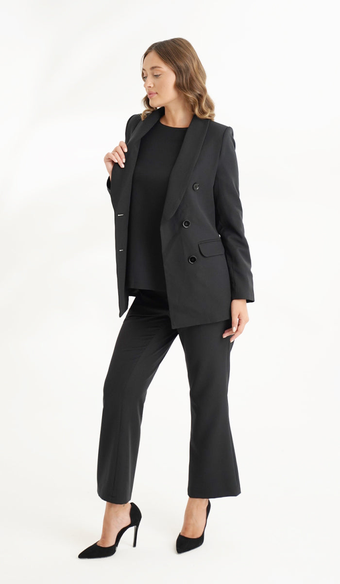 Side full body view of woman wearing full black suit and pants.