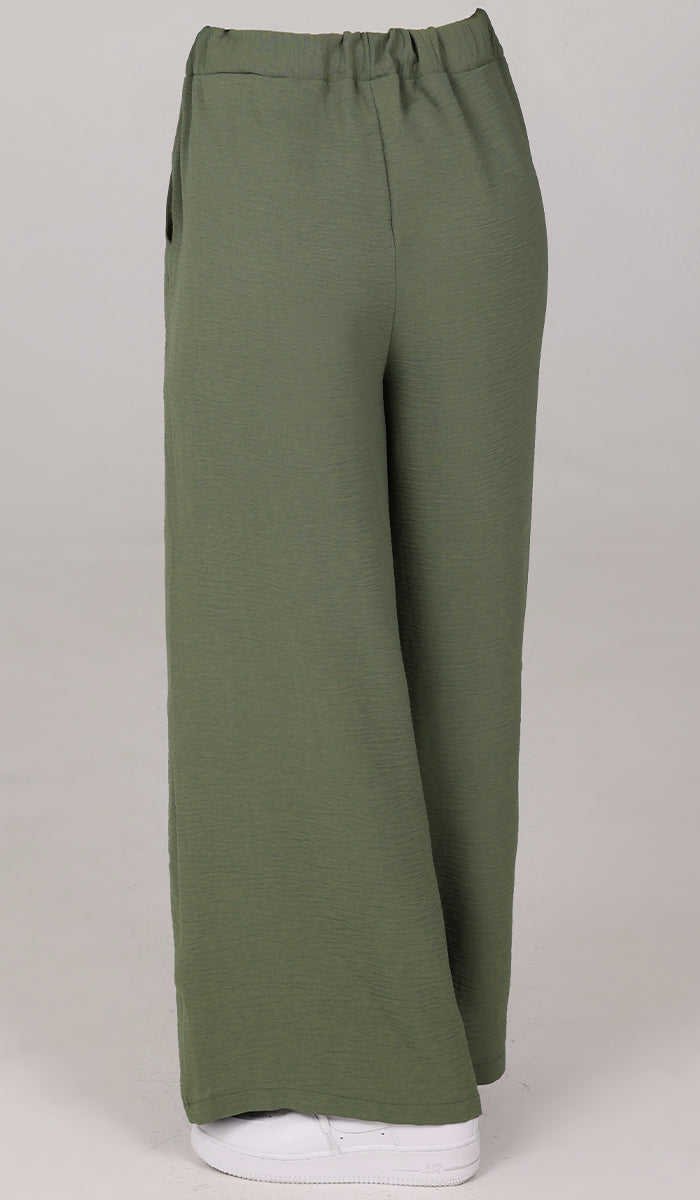 Back view of woman wearing Tina pants in Olive. 